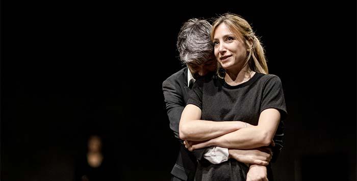 Immagine della locandina di "Il Misantropo" di Molière regia Alberto Lidi. Un uomo e una donna, in primo piano, si abbracciano. Sfondo completamente nero